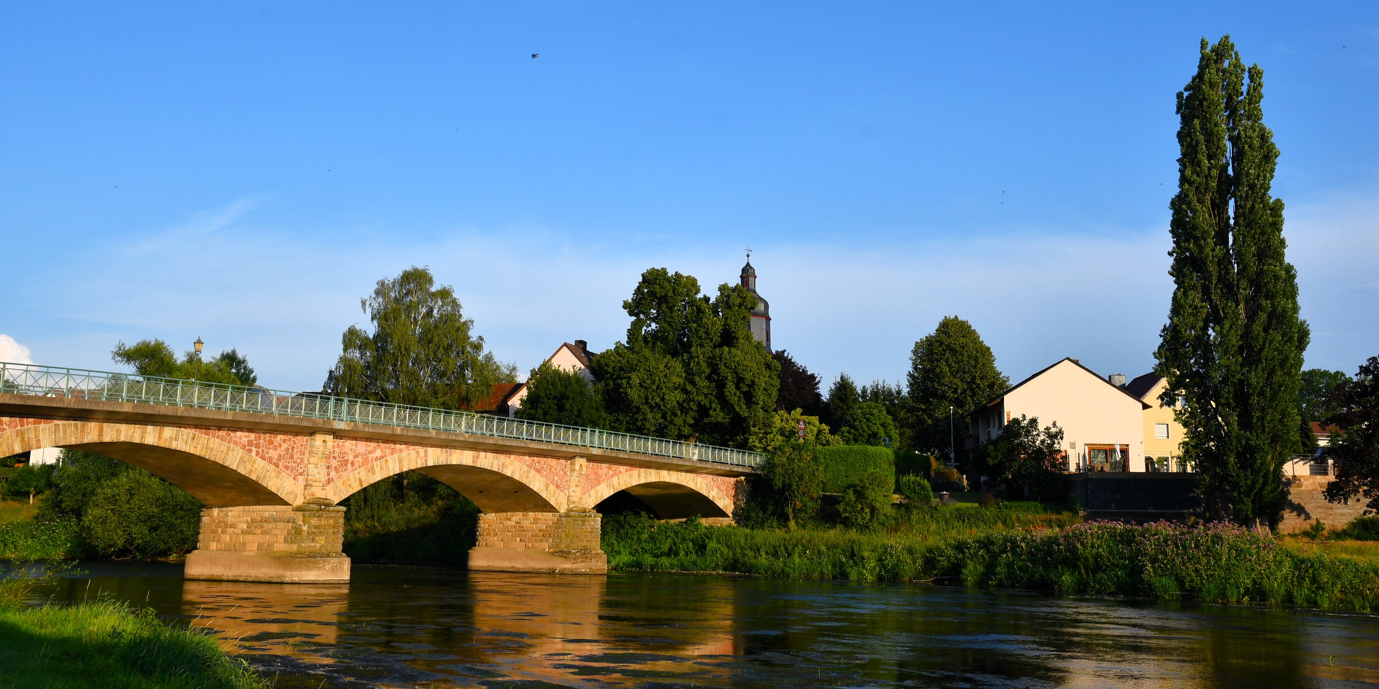 Abendstimmung an der Fuldabrücke mit Kirchturm im Hintergrund