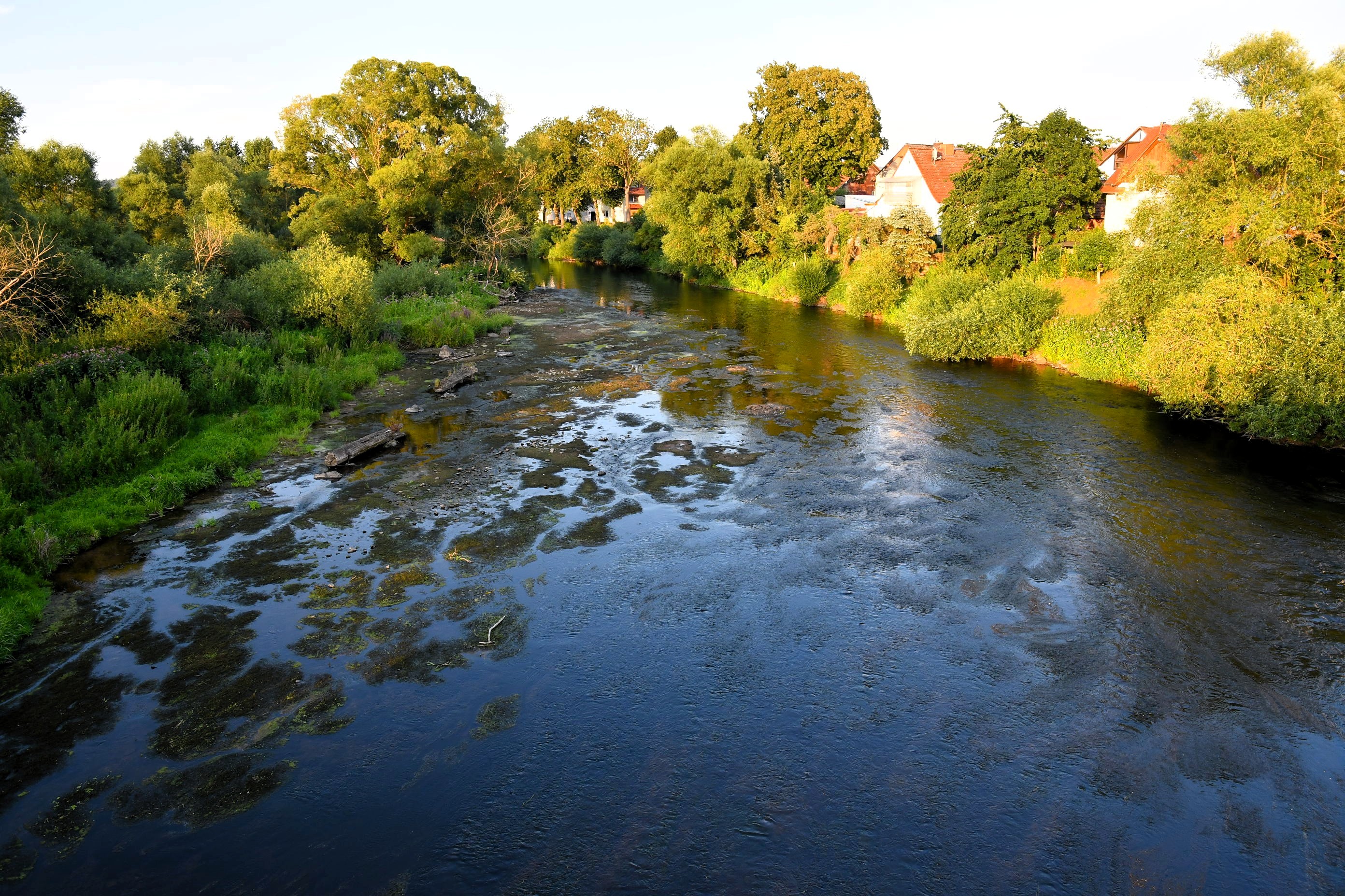 Die Fulda im warmen Abendlicht mit bewaldeten Hügeln im Hintergrund