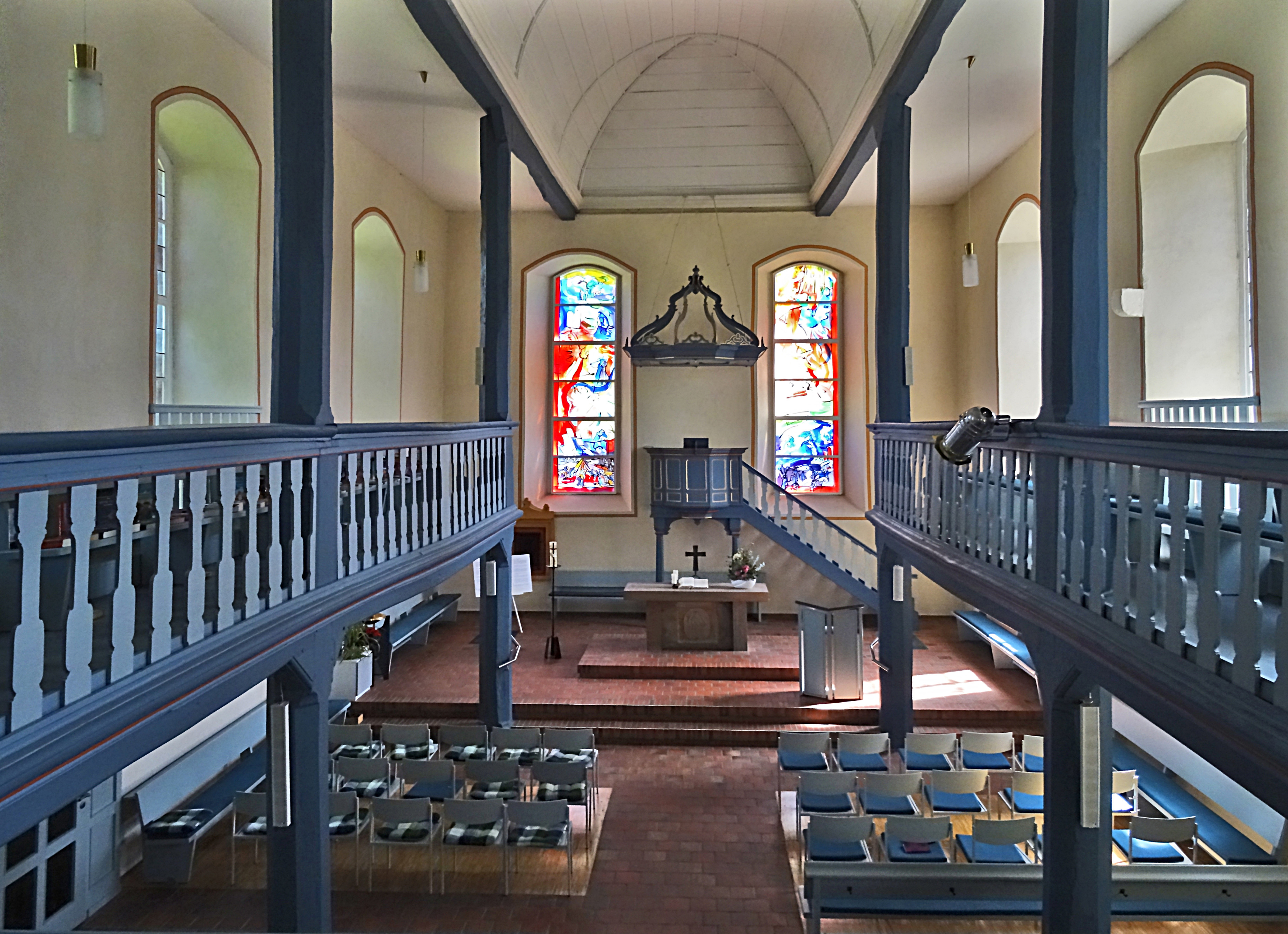 Blick ins Innere der Mecklarer Kirche mit Empore, Kanzel und bunten Fenstern