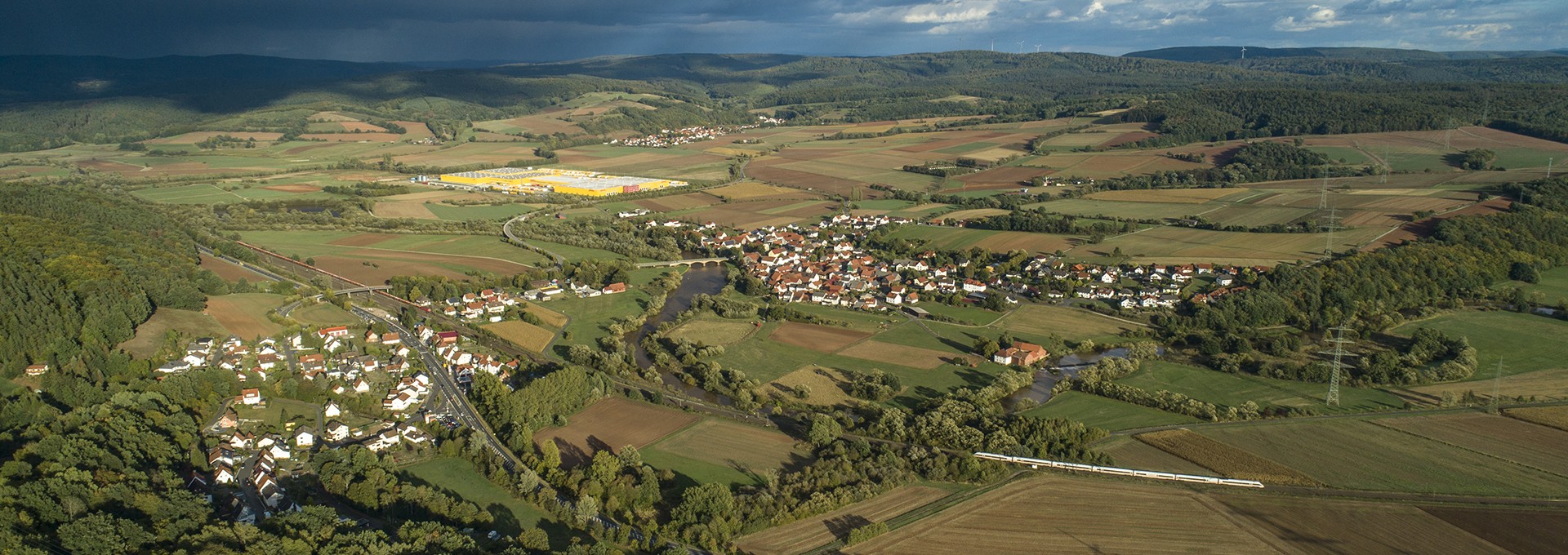 Luftaufnahme vom Steinbachskopf über Mecklar mit Bahnstrecke